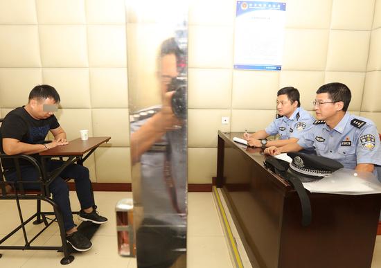 7月27日晚,拱北海关缉私警察依法对潜逃十年的“红通”嫌疑人王某进行讯问。(赵立阳 摄影)