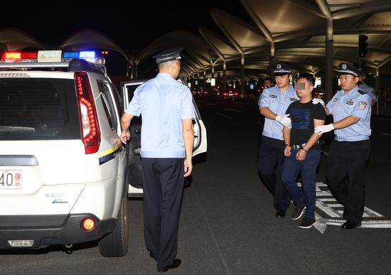 7月27日晚,潜逃十年的“红通”嫌疑人王某被拱北海关缉私警察押解归案。(赵立阳 摄影)