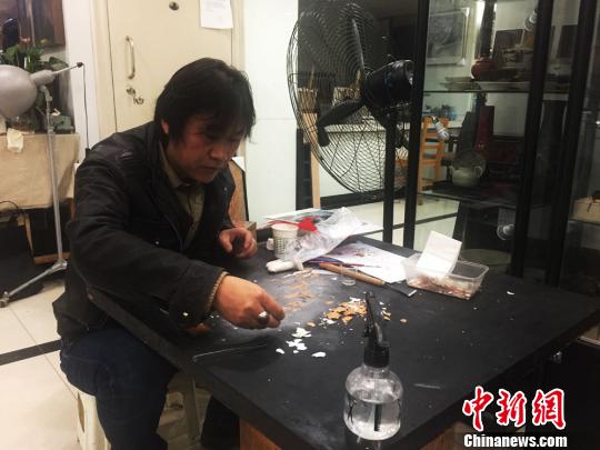 图为刘志刚在蛋壳黏贴漆画作品。 崔琳 摄