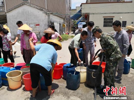 图为当地居民在排队取水　向宇鸣　摄