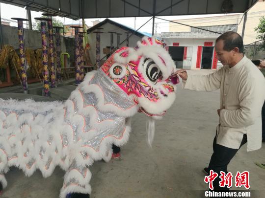 “狮王”李荣仔为做好的狮子点睛。 李凌 摄