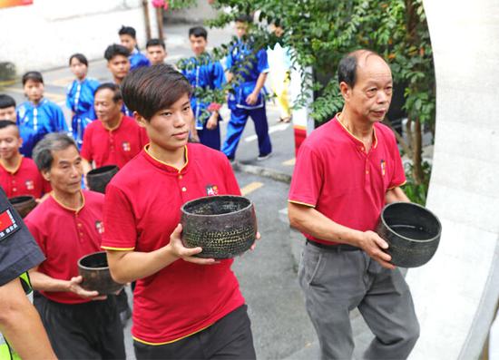鸿胜馆传人从珠江形象大使手中接过铜盘(摄影:吴宇)