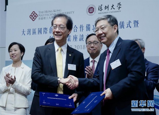 　　2018年7月18日，在香港理工大学，香港理工大学校长唐伟章和深圳大学校长李清泉（前右）签署“大湾区国际创新学院”合作备忘录后握手。