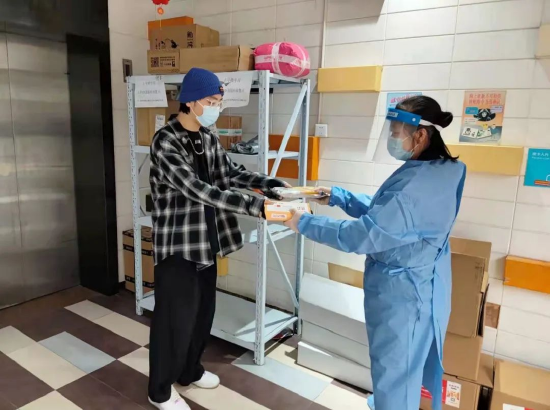 工作人员在将“爱心”预制菜配送给居民