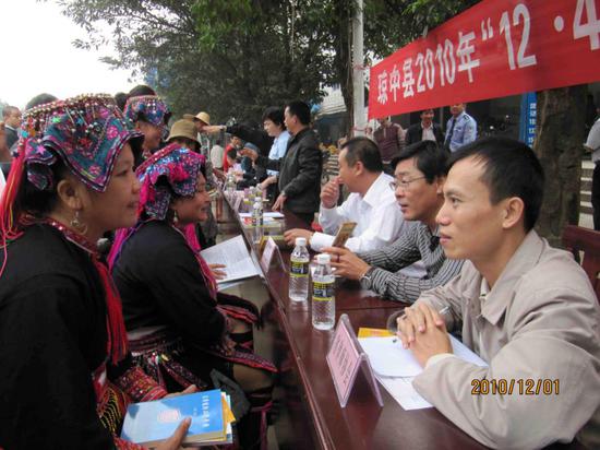 2010年12月1日,郑穗军(右一)和其他志愿律师在海南省琼中县街头接受少数民族群众咨询