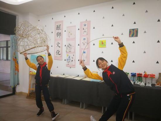 欧琦辉(从左数起第4位)在给学生们讲解扎狮头工艺