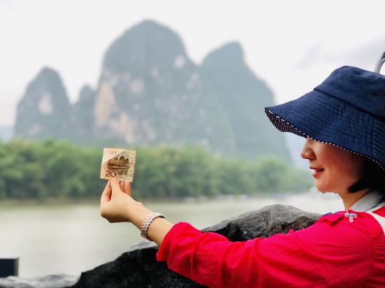 已有一千七百多年历史的兴坪古镇的漓江边，游客于20元人民币背面图的取景地拍摄。