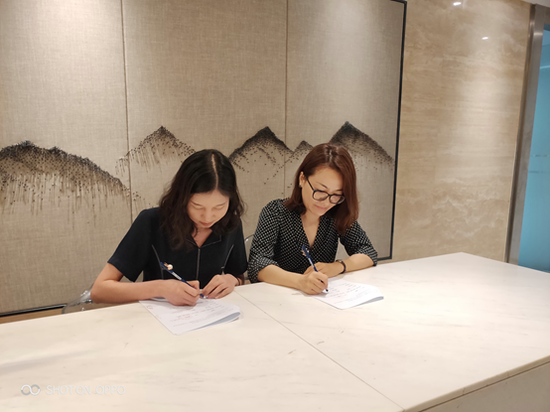 法信云科技公司副总经理肖芸（左）与君直律所TANHOO团队律师向玲之（右）签约