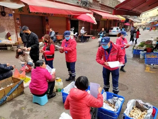 “广州街坊·狮岭一家人”志愿者在农贸市场宣传疫情防控。