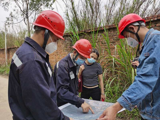 项目经理与施工单位现场沟通输电线路通道超高树木清理事宜。(摄影作者:郝思远)
