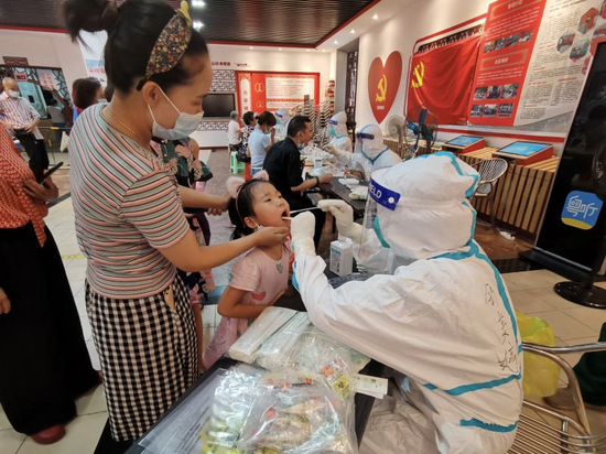 黄埔区支援荔湾区核酸采样医疗服务队队员给小朋友做核酸采样。