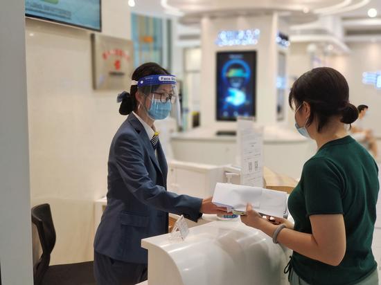 南方电网广东广州供电局营业厅工作人员引导客户办理“一户多人口”业务。