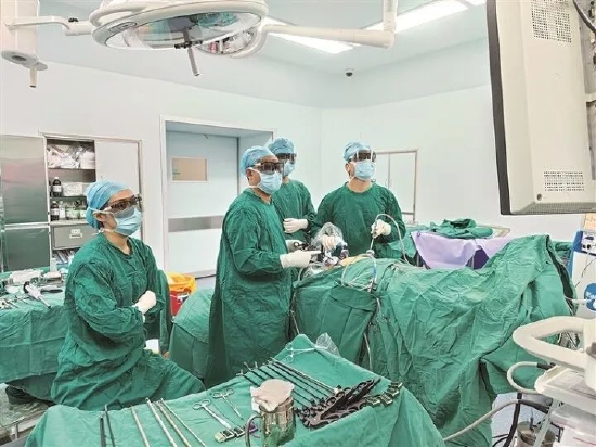 惠州三院消化医学中心主任黄荣辉(右一)为患者施行3D腹腔镜手术