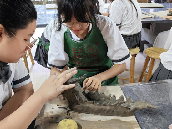(图三:中国教育科学研究院荔湾实验学校学生捏制龙形)
