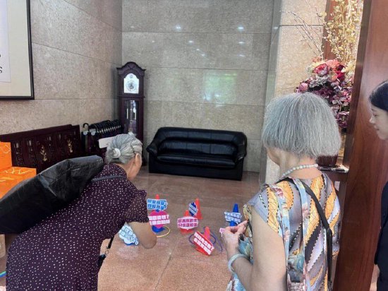 图注:邮储银行工作人员通过“反诈圈圈侠”游戏,向老年群众普及防诈知识