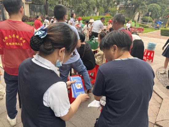 图注:在社区活动中,邮储银行佛山分行工作人员正在向居民耐心讲解手册内容,并解答日常金融疑问