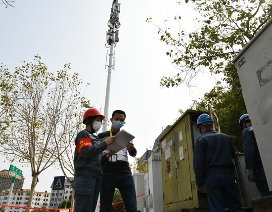南方电网广东惠州惠城供电局运维人员在5G铁塔转改直的施工现场与铁塔公司工作人员核对站点信息台账。温秀云 摄