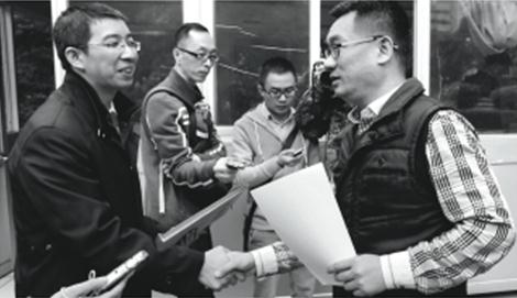 昨日下午,广州律师廖建勋(左)向市交委法规处工作人员递交关于年票的行政复议书。
