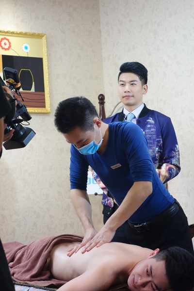 凤凰城店健康导师为电视节目主持人演示点穴手法,进行肠胃调养