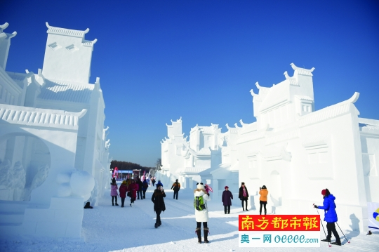 游客在长春“净月雪世界”雪雕小镇中游览。