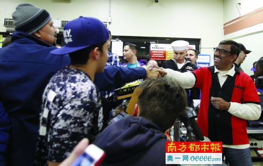 洛杉矶一家“7-11”售出头奖彩票，将获得100万美元奖金，店主（右）欣喜若狂。