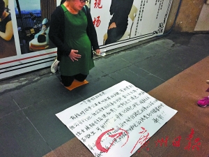 ▲一名孕妇在街头行乞，面前还铺着一份写好的陈情书。