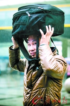 昨日，天河客运站，一旅客在凄风冷雨里赶路。记者陈忧子 实习生郭嘉亮 摄