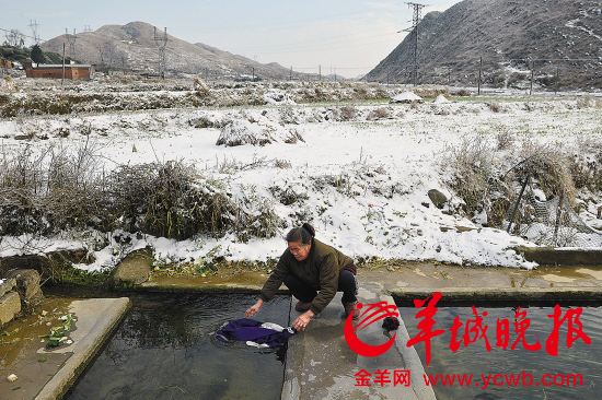 昨日,韶关乳源大桥镇中冲村的村民在冰雪中洗衣服 羊城晚报记者 林桂炎 摄