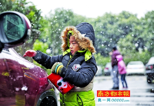 昨日中午，番禺南浦，一名孩子拿着小罐子装雪。