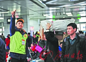 广州火车站,志愿者在引导乘客有序上车。 广州日报记者乔军伟 通讯员吴尚璋 摄