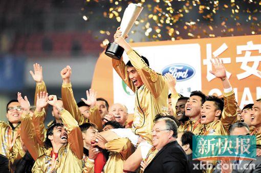 ■广州恒大淘宝队队长郑智(上)与队友、教练等在颁奖仪式上庆祝。 新华社发