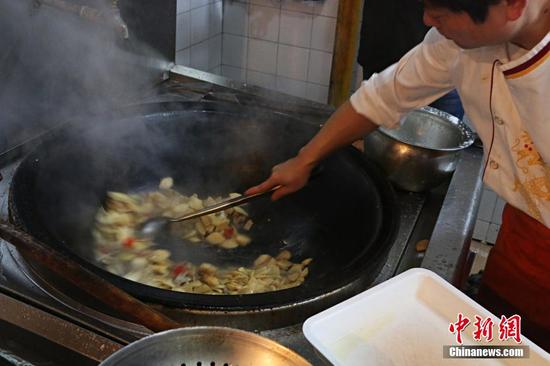 厨师正在炒苹果肉片。 图片来源：视觉中国