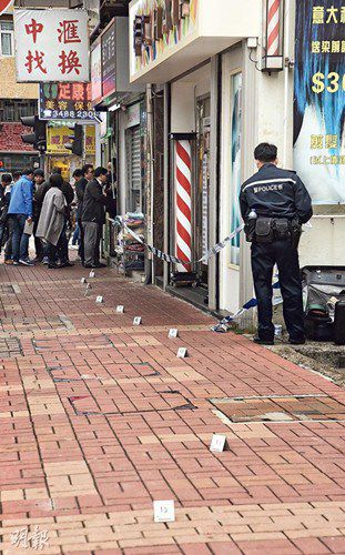 香港昨发生兑换店恐怖劫杀案,现场留下凶徒逃走时的血鞋印,由兑换店内一直伸至街外10多米长。事后警员封锁现场,及以纸牌作标记调查。