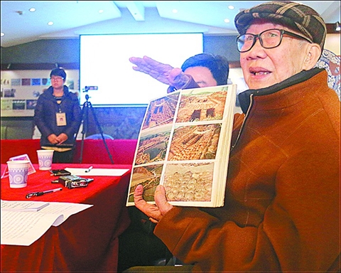 昨日发布会上，区博物馆前馆长仇荣佳展示画册介绍遗址发掘时的珍贵照片。/通讯员曾锦峰供图