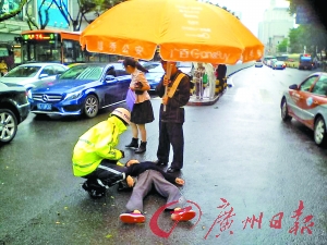 交警在雨中为晕倒的市民撑伞。