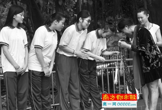 5月9日，广州市信息工程职业学校东莞庄校区的升旗仪式上，62岁的纪录女士向四位女生赠送锦旗。 南都记者 冯宙锋 摄