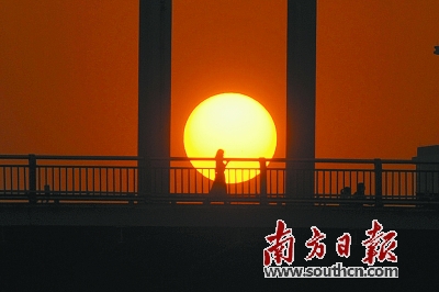暴雨后的佛山迎来晴天。图为11日傍晚夕阳映照下东平桥上的归家人。南方日报记者 戴嘉信 摄