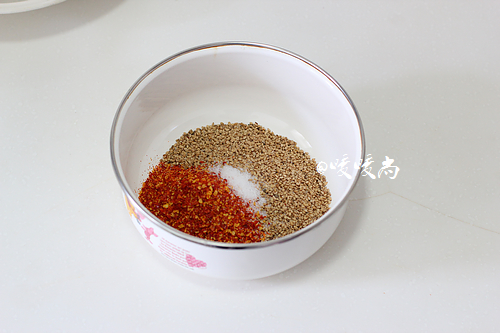 6.取一耐热的容器，放入白芝麻和一点点盐和三分之一的辣椒末。