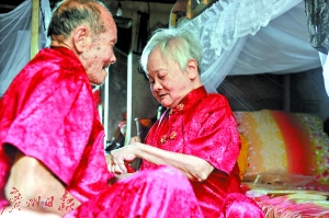 两位老人穿上了喜庆的新人装。