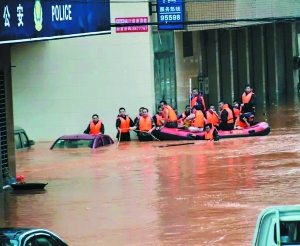 消防官兵通过橡皮艇强渡洪水围困区域，搜救被困群众。通讯员供图