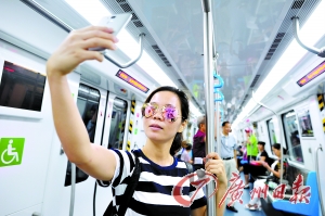 市民纷纷“尝鲜”，体验地铁的便利。图为一位女士在车厢里拍照留念