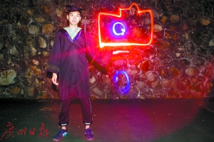 穿上学士服,热爱摄影的同学在自己的身边绘出了一台相机的形状。