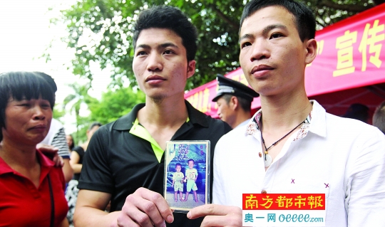6月1日，深圳龙岗富民公园，弟弟(中)与被拐21年的亲哥哥(右)相认，母亲在一旁喜极而泣。