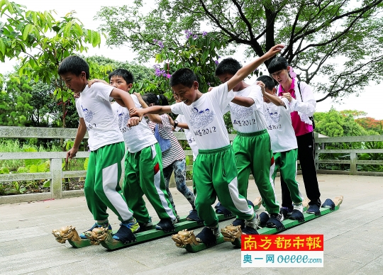 昨日，龙溪小学的学生在荔湾区大沙河旁进行旱地龙舟比赛。