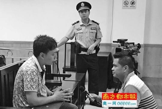 钟涛(左)在庭审结束后接受媒体采访，他说自己觉得委屈。 南都记者 朱鹏景 摄