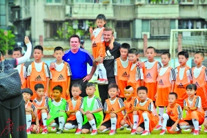 熟练地抱起小学生合照，奶爸气质尽显。