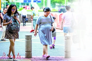 广州市妇女儿童医疗中心珠江新城院区，孕妇从医院大门中走出。 　　广州日报记者陈忧子摄