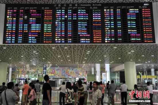 8月1日,深圳机场,到达大厅的显示屏上滚动播放着被取消航班的信息。当日,受台风“妮妲”影响,深圳机场启动三防红色预警,各航空公司已在深圳机场取消8月1日至2日两天进出港航班140班。 中新社记者 陈骥旻 摄