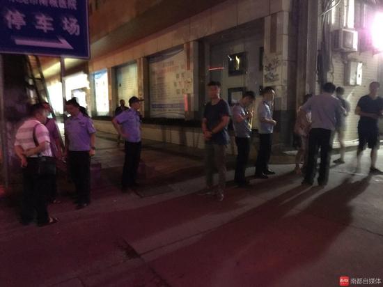 东莞南城医院门口，看完尸体后，家属围着民警询问案件细节。