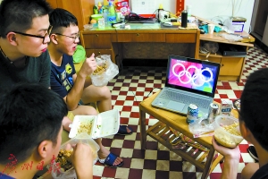几位年轻人在集体宿舍观看奥运比赛。